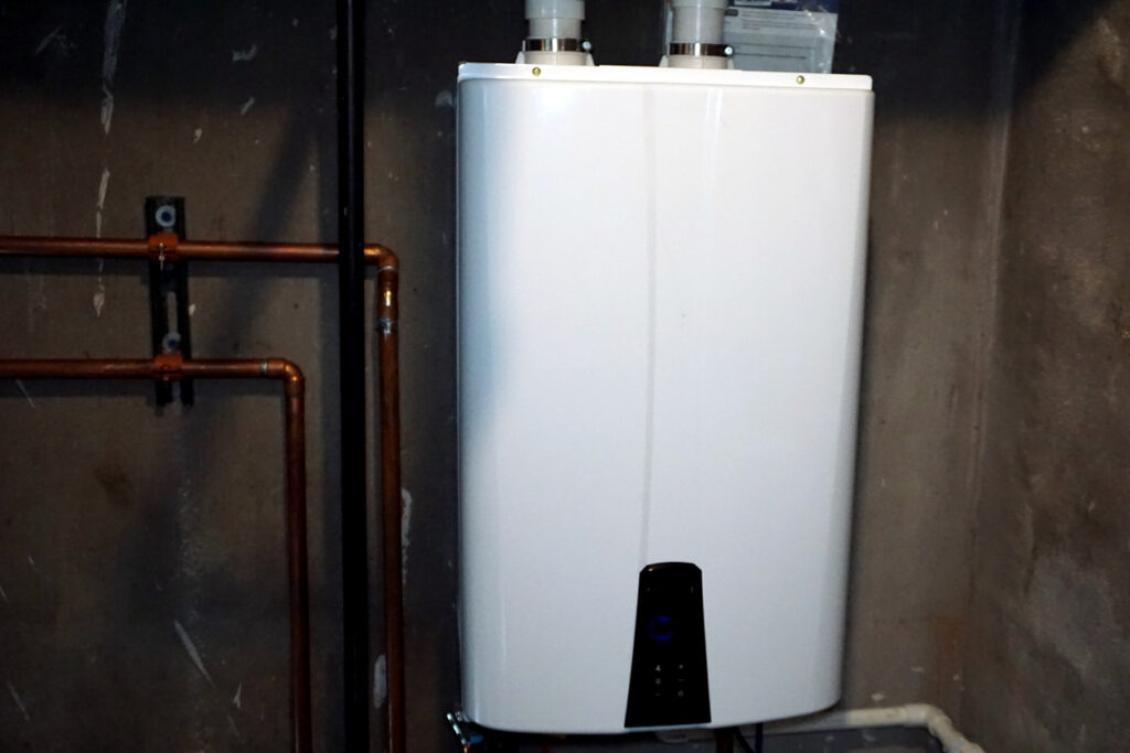 Tankless hot water heater installed in a basement utility room